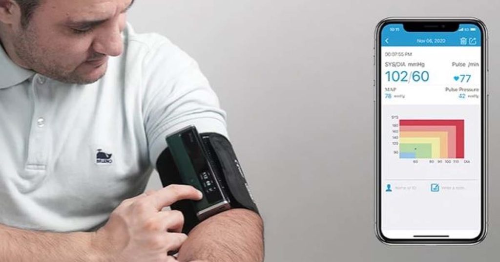 patient using remote patient monitoring device to check their blood pressure and other health vitals