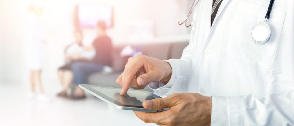 A doctor using a tablet to monitor patient vitals